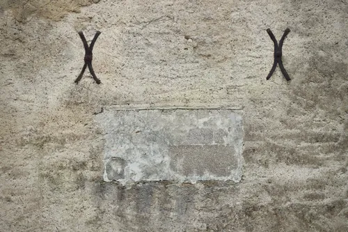 Détail d'une ancre de fixation en fer scellée dans un mur