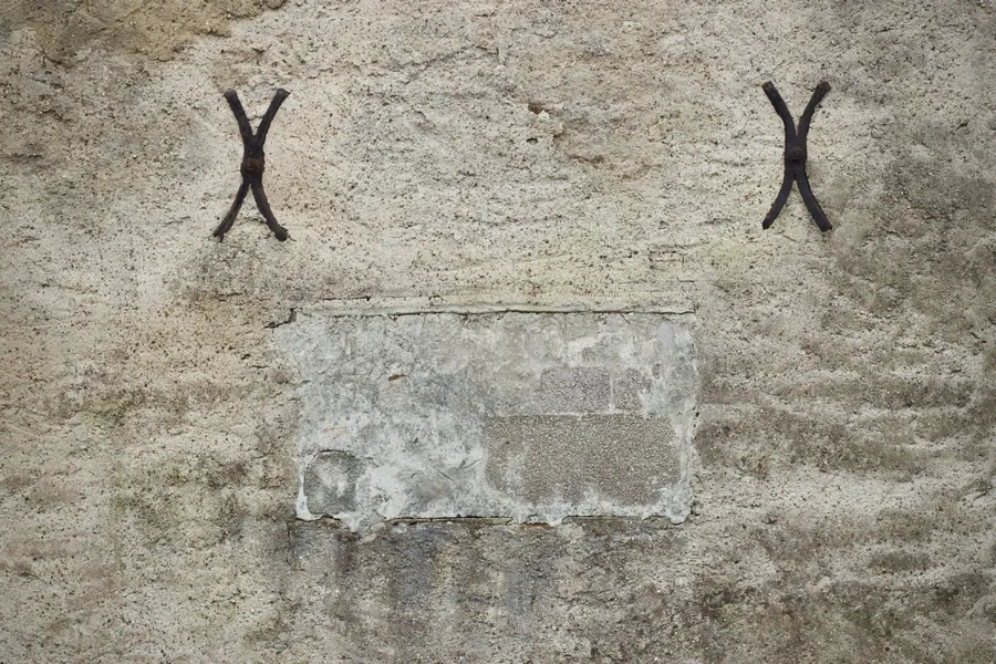 Détail d'une ancre de fixation en fer scellée dans un mur